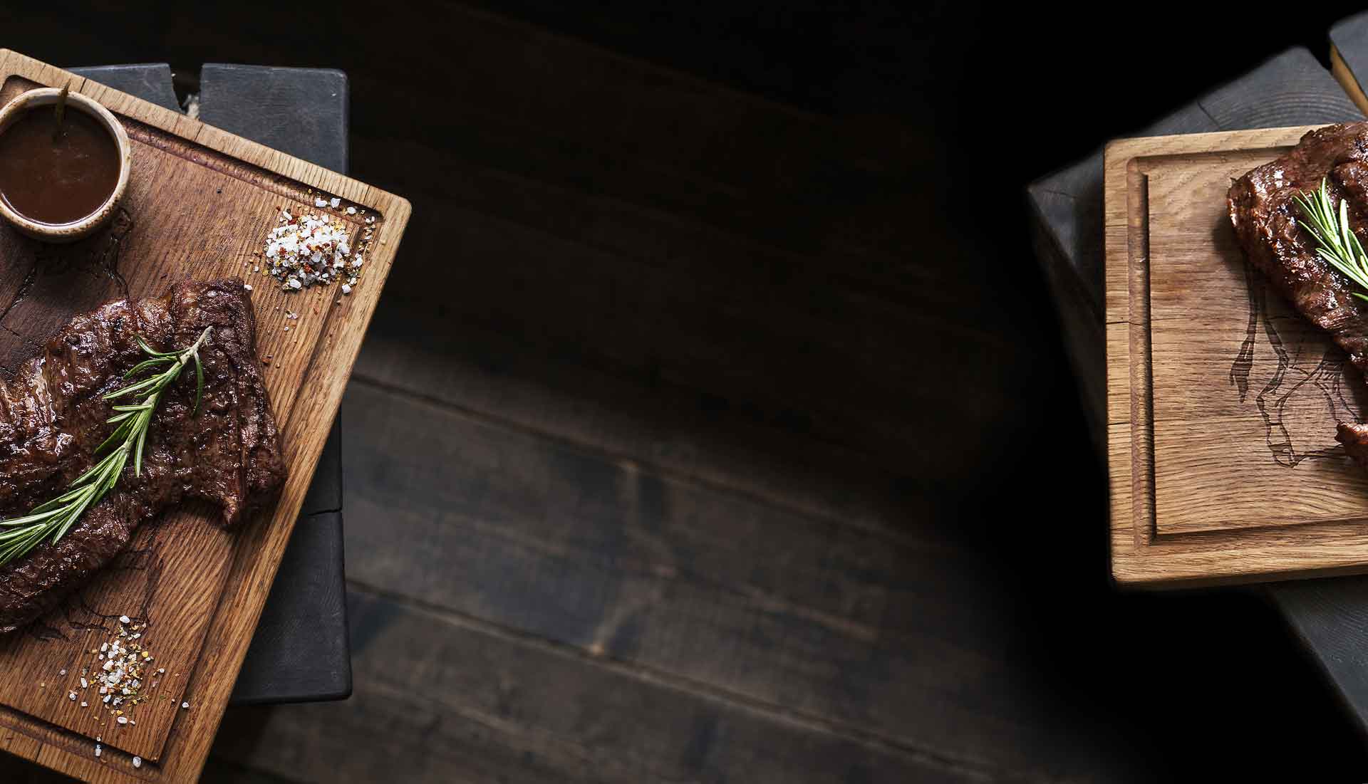 Grilled steak with rosemary and sea salt on wooden boards